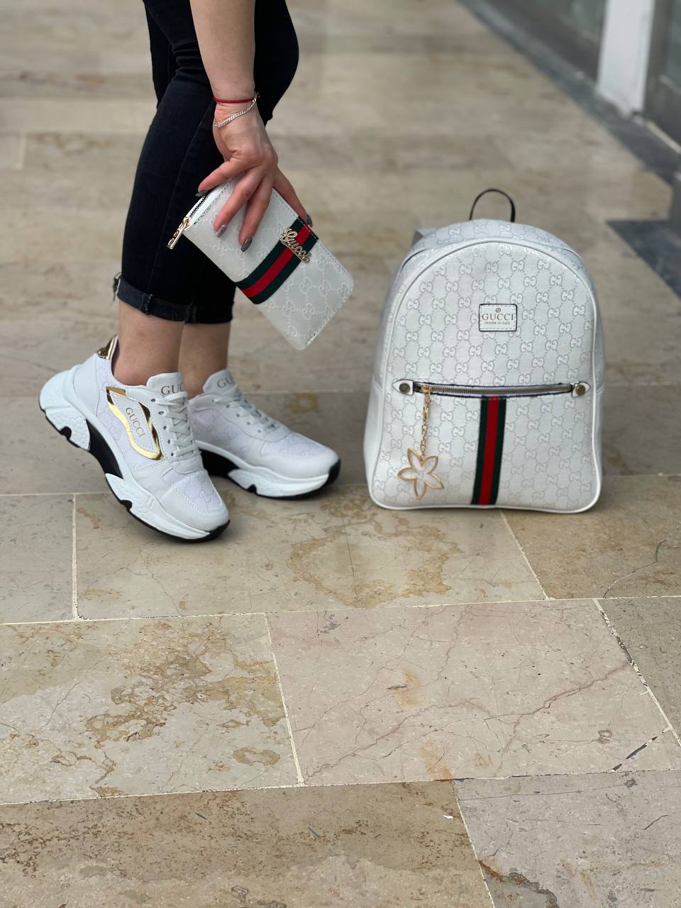 White Sneakers set with GG lettering next to the shoes